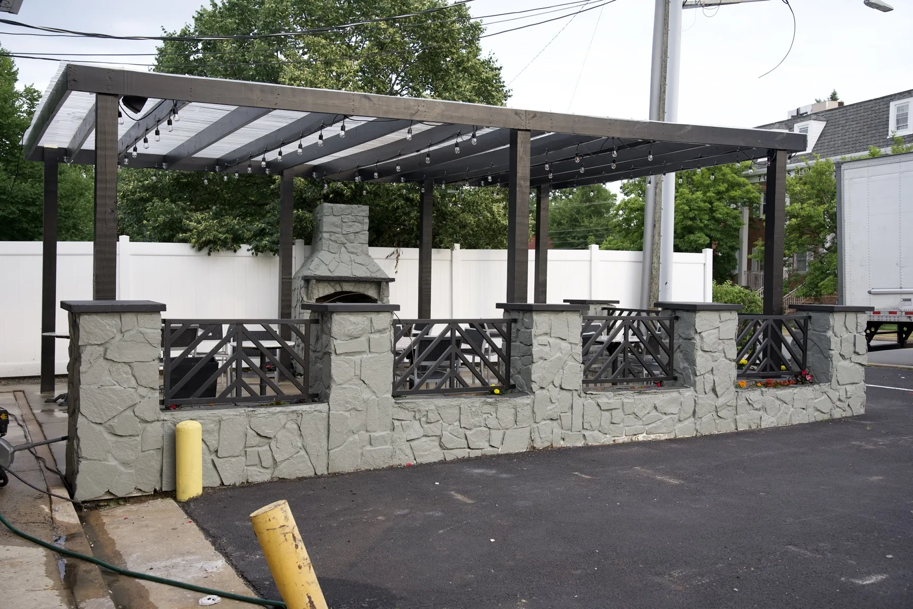 Outdoor patio with pergola seating and a stone fireplace
